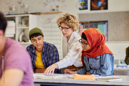 Wallpaper Mural Female teacher assisting teenagers students at high school Torontodigital.ca