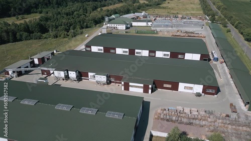 Aerial footage capturing a modern industrial facility with green rooftops and clear production zoning. The site is surrounded by greenery and roads, emphasizing both infrastructure