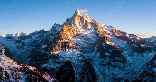 Majestic snow-capped mountain at sunrise with clouds