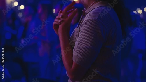 Female interpreter signing worship song passionately, hands expressing lyrics with blurred congregation background during church service