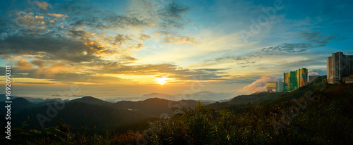 Obraz na płótnie Sunrise illuminating lush valley and buildings in genting highlands, malaysia