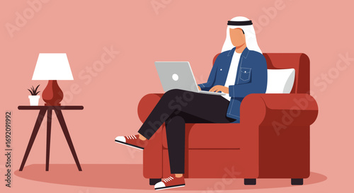 Arab man in traditional headwear and casual attire works remotely on a laptop from a cozy armchair in a modern home setting, representing a connected lifestyle.