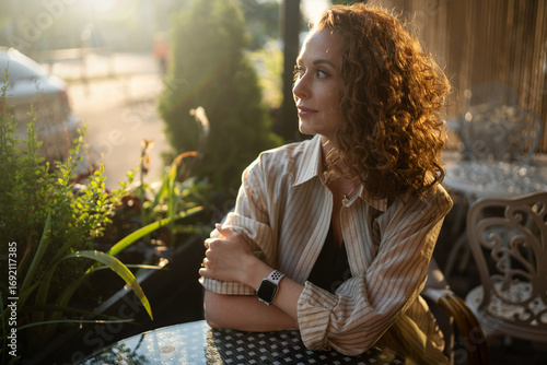 Businesswoman relaxing in a sunlit cafe setting