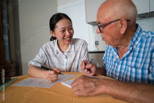 Senior man learning Mandarin with an asian woman teacher