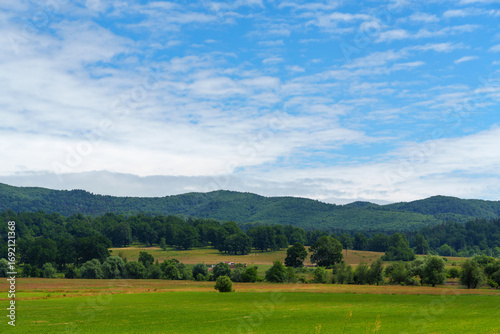 beautiful spring landscape, view to fields and village, in the distance Carpathian mountains