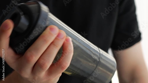 An athlete uses a shaker to mix sports nutrition, protein or creatine after exercise.
Black shaker for protein.
Using sports nutrition and supplements for muscle growth and strength gain