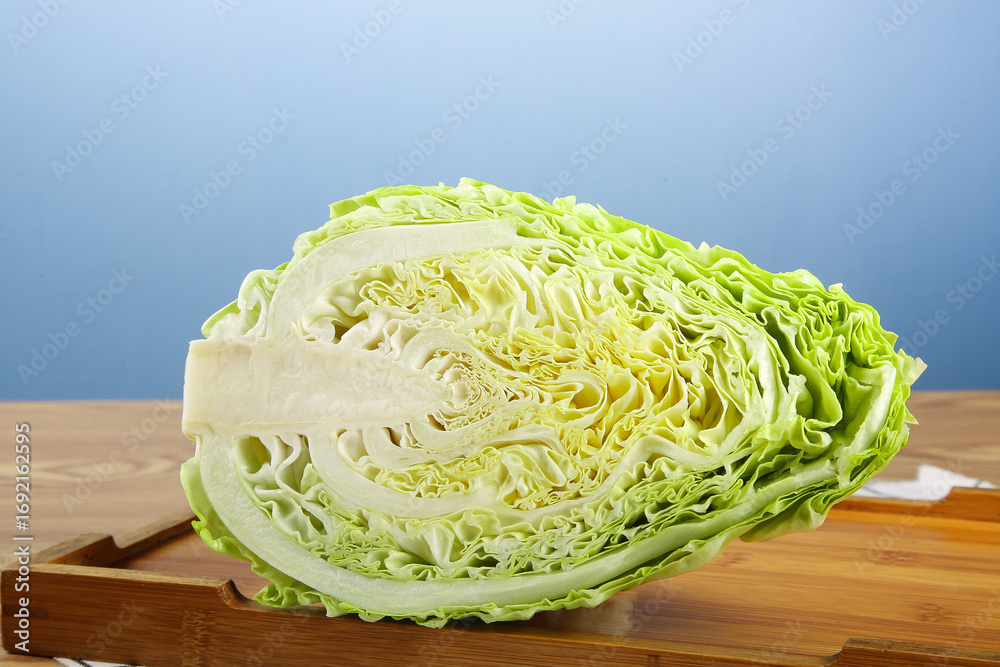 Fototapeta premium Fresh Cabbage Half Cut on Wooden Cutting Board - Healthy Vegetable Ingredient for Cooking