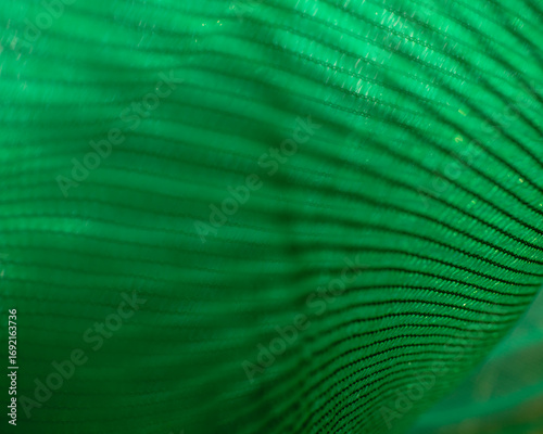 Green fabric for shading, used in nurseries to block sunlight for plants and vegetables.