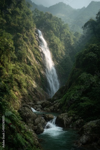 Tropical waterfall surrounded by lush, green forested cliffs.