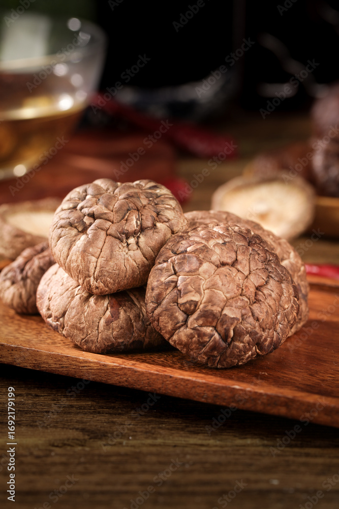 Fototapeta premium Dried Wild Mushrooms on Wooden Board - Aromatic Culinary Ingredients Still Life Photography