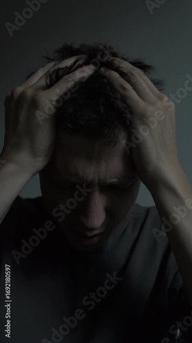 Young man suffering from severe migraine headache, dark dramatic scene health problem concept, vertical video