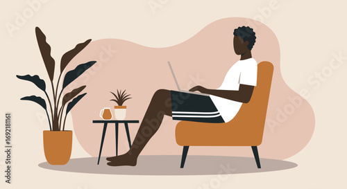 Young man comfortably working or studying from home on his laptop, embracing a modern, flexible lifestyle in a cozy setting.