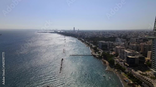 Wallpaper Mural Drone video captures expansive shoreline of Durrës, Albania, with shimmering sea, breakwaters, towering skyscraper, and urban landscape under clear sky. Stunning aerial footage. Torontodigital.ca
