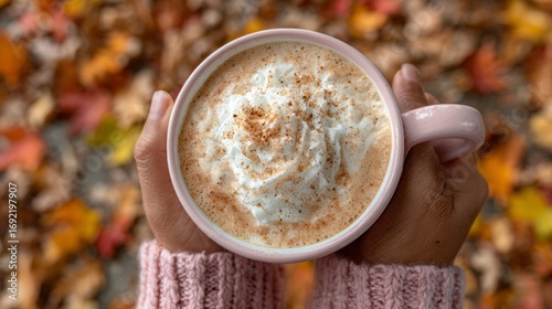 Fototapeta Naklejka Na Ścianę i Meble -  Cozy autumn day with a warm mug of pumpkin spice latte surrounded by colorful fallen leaves