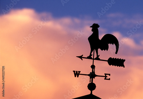 Silhouette of weather vane against sky at sunset