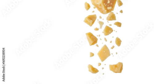 Golden-yellow parmesan cheese pieces and translucent flakes dynamically falling against a transparent studio background with copy space, high-key lighting. Culinary ingredient concept
