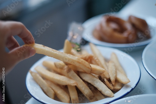 Photography french fries with fried onion, hand, motion, fast food