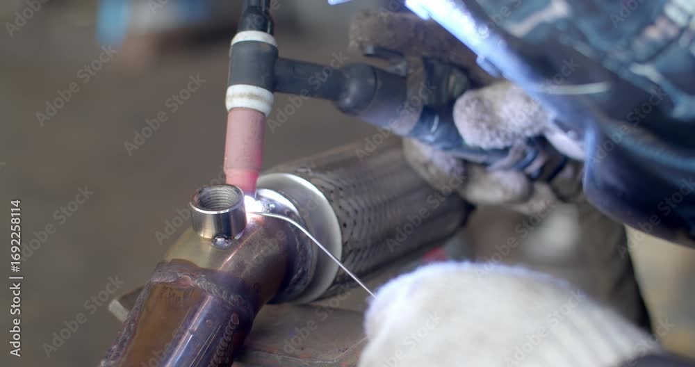 Technician is welding pipe to add position of o2 sensor.Car pipe ...