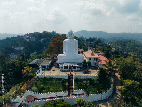 Aerial view of the colossal white Bahirawakanda Vihara Buddha statue atop a hill, overlooking the vibrant cityscape, Kandy, Central Province, Sri Lanka.