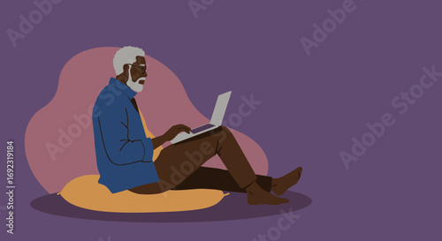 An older Black man sits comfortably on cushions, focused while using a laptop. Ideal for themes of remote work, technology, digital literacy, or leisure for seniors.
