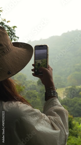 Young Woman Filming Scenic Rice Terraces with Smartphone in Northern Thailand