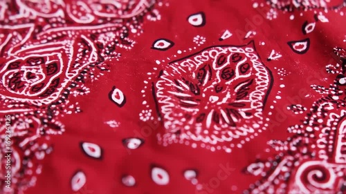 Close-up of a red bandana with intricate white and black paisley patterns