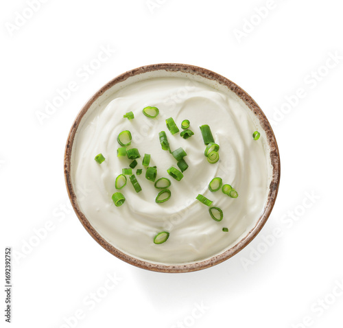Sour cream or yogurt in white bowl isolated on white background. Thick sour cream with green chopped onions. Top view.
