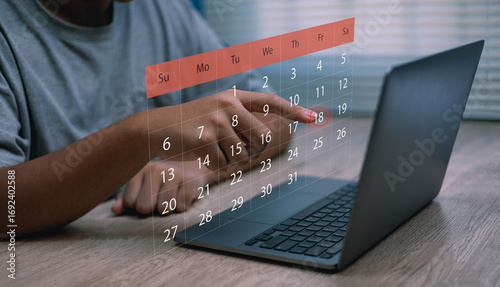Man pointing at digital calendar on laptop screen,Concepts of online scheduling event planning ,time management and digital productivity tools