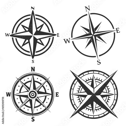 A collection of four distinct black and white compass rose designs each representing cardinal directions and offering a classic navigational symbol