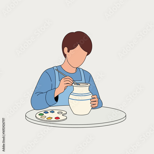Person painting a ceramic jug with colorful paints on a table.