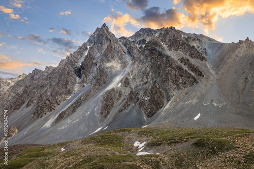 Majestic mountain range with rugged peaks and scree slopes under a beautiful sunset