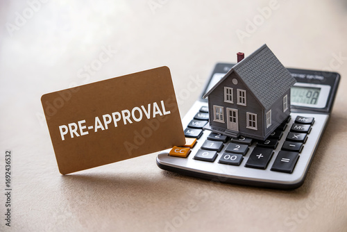 Miniature house on calculator with pre approval card home finance
