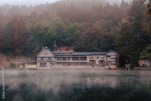Canvas Print Serene lakeside Japanese inn with misty forest backdrop.