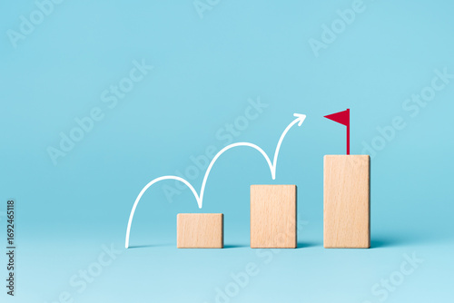 Ladder of success in business growth concept. Wooden block stacking as step stair with arrow up and flag target icon. copy space