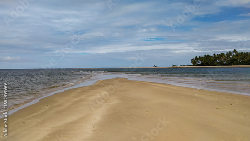 The crystal blue waters of Castelhanos Beach sparkle under the tropical sun on Boipeba Island, Bahia, Brazil.