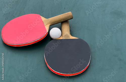 Two ping pong rackets and ball on table