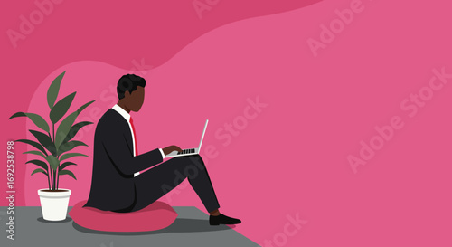 Professional Black man working remotely on a laptop, sitting comfortably on a cushion at a modern home office with a plant. Focus on productivity and flexible work.