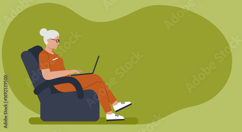 A senior woman comfortably uses her laptop while sitting in an armchair, depicting modern connectivity and a relaxed lifestyle.