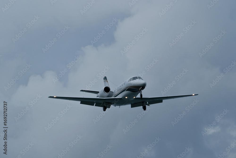 Fototapeta premium Airplane in the cloudy sky. Private plane in flight, Business jet in the sky.