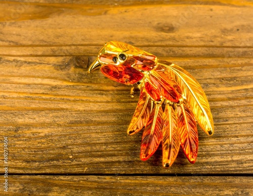 Ornate bird brooch on wood