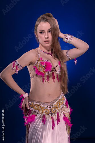 Dancer with long hair in bright oriental costume dancing belly dance 