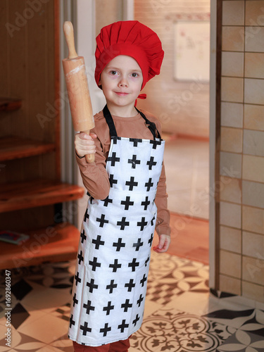 Smiling boy holding rolling pin for Christmas gingerbread cookies
