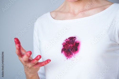  Dirty red fruit and wine stain on white clothes. The rich color contrasts sharply against the fabric, showcasing the mess made while eating. Daily stains cleaning care