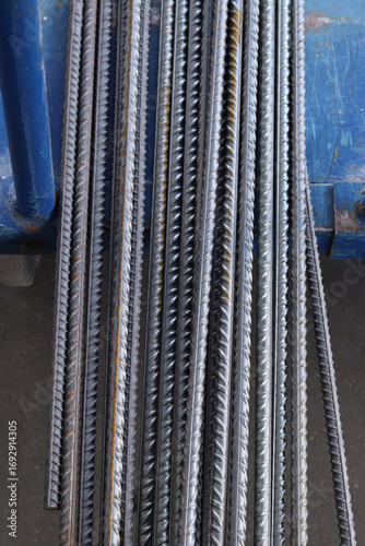 Reinforcement at the metal warehouse, selective focus. Construction iron rods with rust spots. Close-up of steel reinforcement. Warehouse of building materials. Repair and construction concept