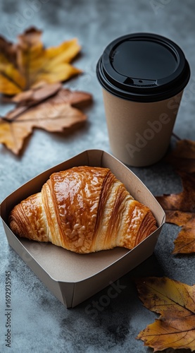 Enjoying a Warm Croissant With Coffee on a Cozy Autumn Morning