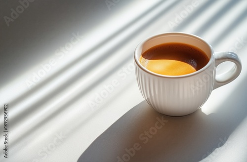 Morning Coffee Cup Resting on a Table With Sunlight Casting a Shadow in a Coz...