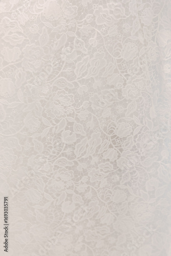 Quadro su tela Intricate lace texture featuring floral patterns on a white fabric backdrop capt