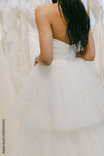 Photography Elegant bride trying on a beautiful white tulle wedding dress in a dress studio