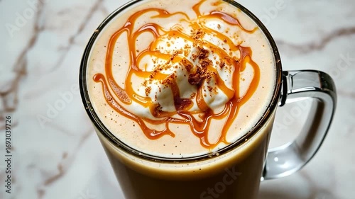 Closeup of Caramel Drizzled Whipped Coffee in Glass Mug on Marble Surface