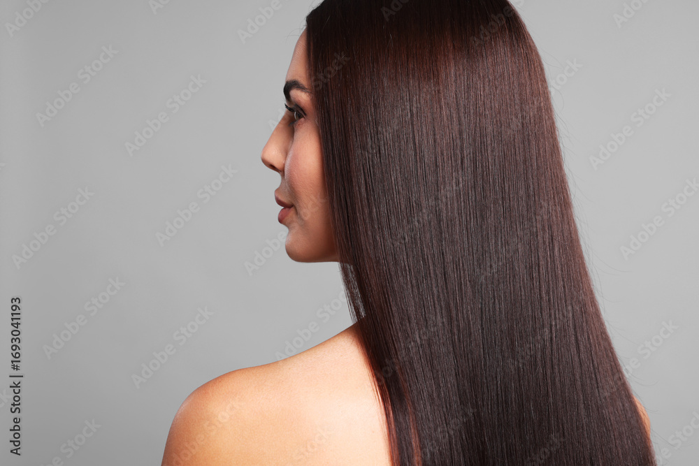 Fototapeta premium Woman with beautiful smooth hair after lamination procedure on light grey background, back view. Space for text